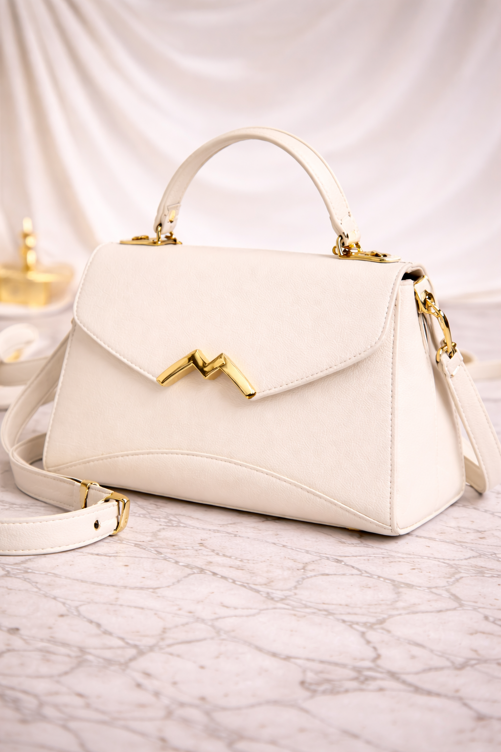 Geantă de damă alb ivory, cu design elegant și detalii aurii, ideală pentru completarea ținutelor moderne. Realizată din piele ecologică de calitate, această geantă oferă un echilibru perfect între stil și funcționalitate.