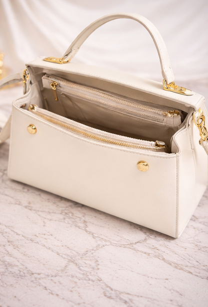 Geantă de damă alb ivory, cu design elegant și detalii aurii, ideală pentru completarea ținutelor moderne. Realizată din piele ecologică de calitate, această geantă oferă un echilibru perfect între stil și funcționalitate.