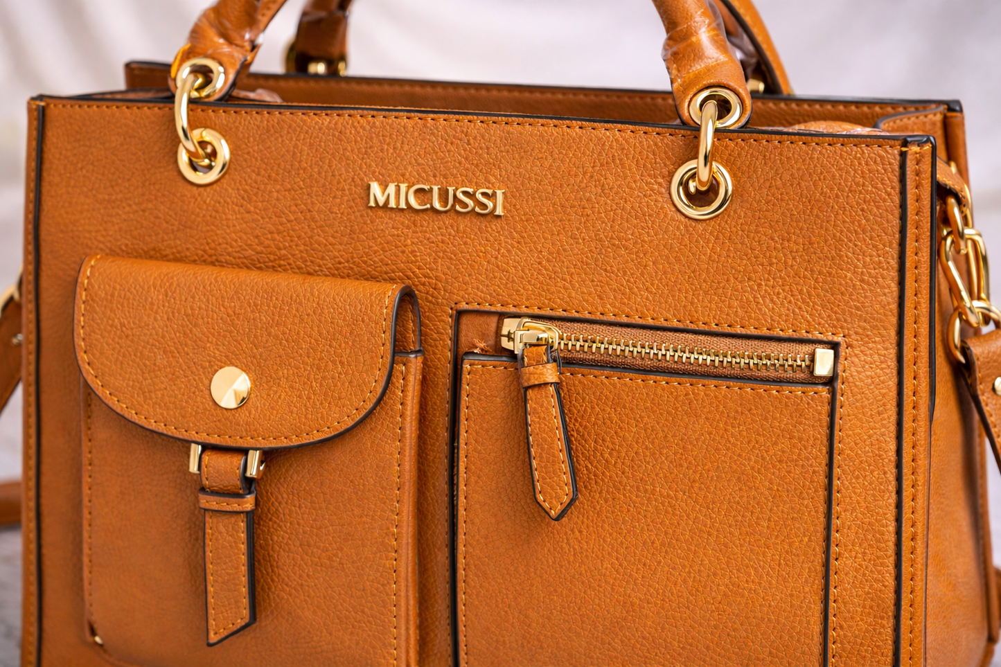 Geantă de damă structurată maro, cu buzunare exterioare și finisaje aurii. Design elegant, piele ecologică premium. Descoperă MEQUEEN.