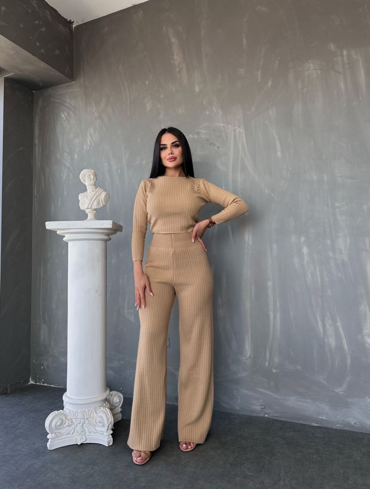 Compleu de damă din tricot striat (reiat), format din două piese. Setul include o bluză cu mâneci lungi și aplicații decorative (perle/tinte) pe umeri, și pantaloni cu talie înaltă și croială largă (wide leg)