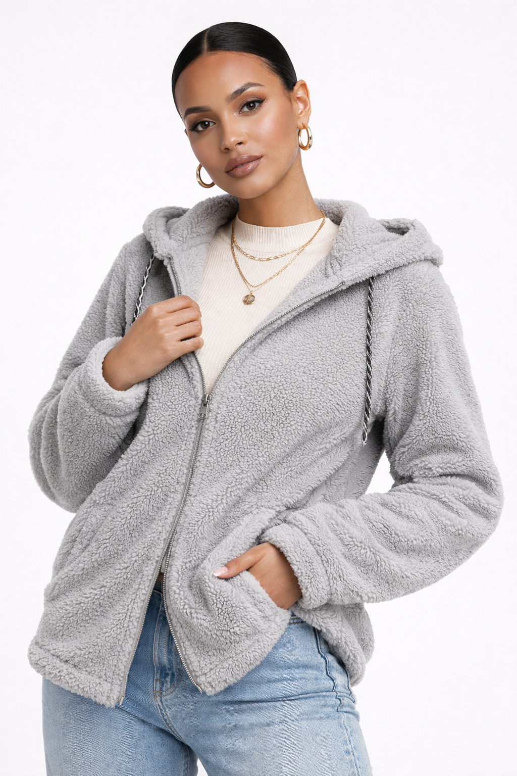 Geacă casual din material pufos tip teddy (blăniță de ursuleț), prevăzută cu glugă reglabilă cu șnur. Modelul se închide cu fermoar și dispune de buzunare laterale practice