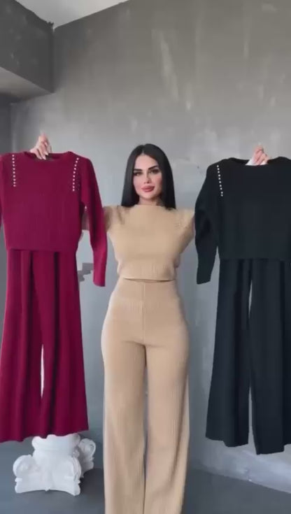 Compleu de damă din tricot striat (reiat), format din două piese. Setul include o bluză cu mâneci lungi și aplicații decorative (perle/tinte) pe umeri, și pantaloni cu talie înaltă și croială largă (wide leg)